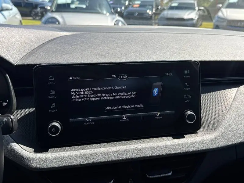 Vue rapprochée de l'écran tactile central noir du tableau de bord d'une Skoda Scala bleu 2025, avec interface Bluetooth affichée.