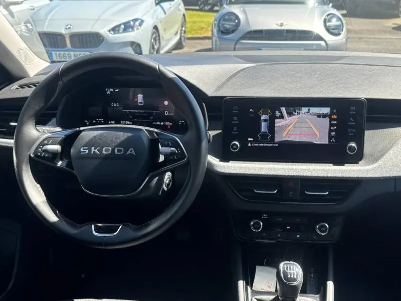 Vue intérieure du tableau de bord et volant noir d'une Skoda Scala 2025 avec écran tactile affichant la caméra de recul.