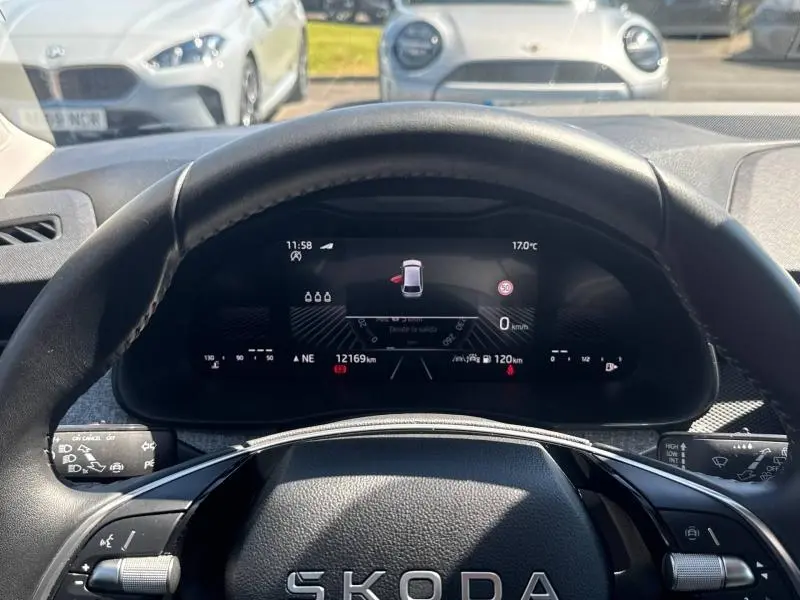 Vue intérieure centrée sur le tableau de bord numérique et le volant cuir d'une Skoda Scala bleu, affichage multifonction actif.