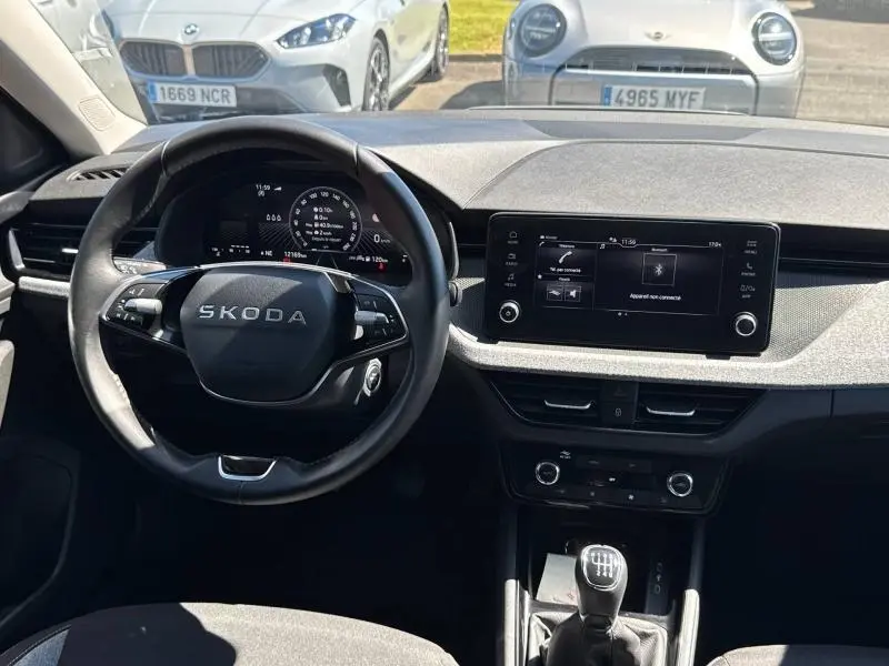 Vue intérieure avant de la Skoda Scala 2025, volant cuir multifonction et écran tactile central avec boîte manuelle.