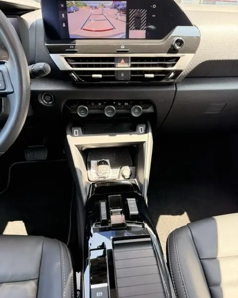 Vue intérieure centrée sur la console centrale et l'écran tactile affichant la caméra de recul du Citroën C4 gris foncé.