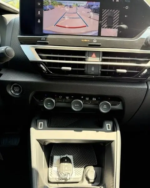 Vue intérieure du tableau de bord de la Citroën C4 2025, écran tactile affichant la caméra de recul et commandes climatisation.