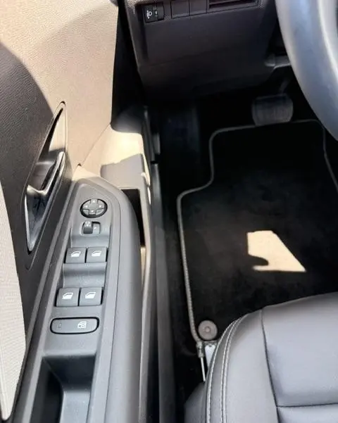 Vue intérieure côté conducteur de la Citroën C4 2025, montrant les commandes des vitres et rétroviseurs sur la porte noire.
