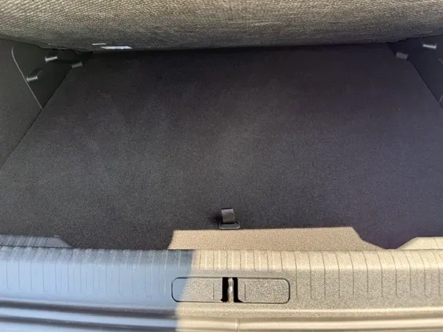 Vue rapprochée de l’espace de rangement sous le plancher du coffre d’une Citroën C4 gris foncé, version Essence 130 EAT8 MAX.