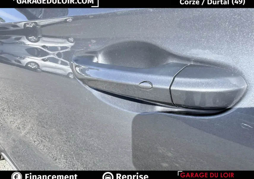 Poignée de porte gris clair du MG Motor ZS 1.5L Hybrid+ Luxury 2025 avec reflet et bouton de déverrouillage.