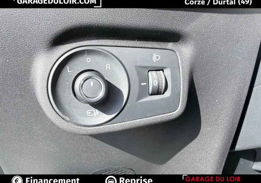 Gros plan sur la commande de réglage des rétroviseurs et des phares d’un MG ZS gris clair 2025.