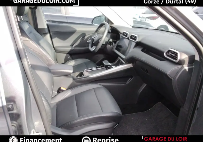 Intérieur avant droit du MG ZS gris clair 2025, sièges cuir noirs et tableau de bord avec écran tactile central.
