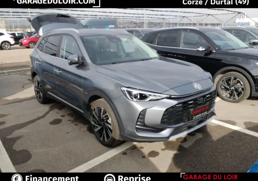 MG ZS gris clair en 3/4 avant droit, avec calandre noire et jantes alliage noires distinctives.