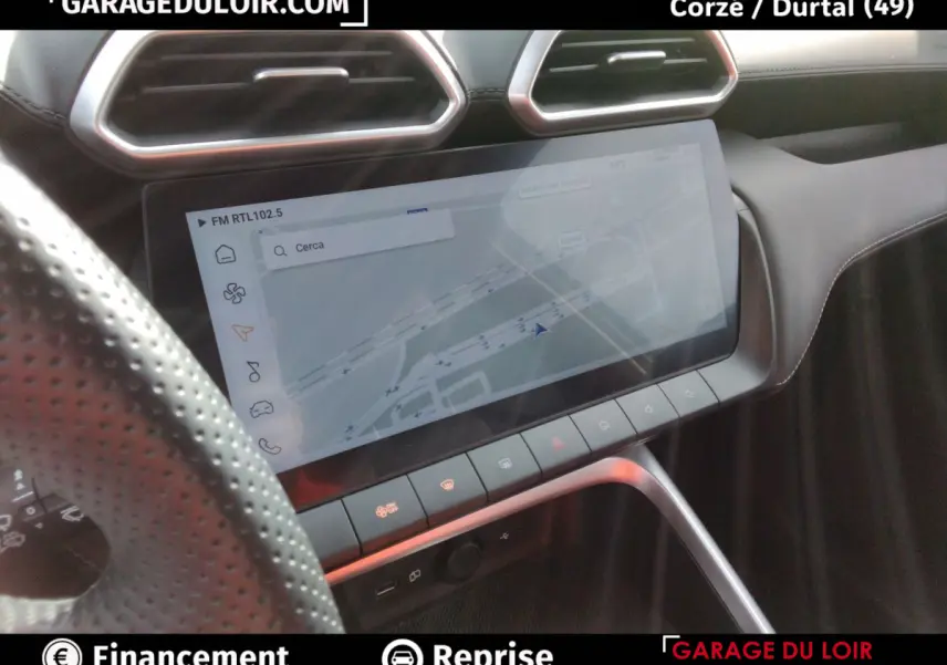 Vue intérieure du tableau de bord du MG Motor ZS gris clair, avec écran tactile central affichant la navigation.
