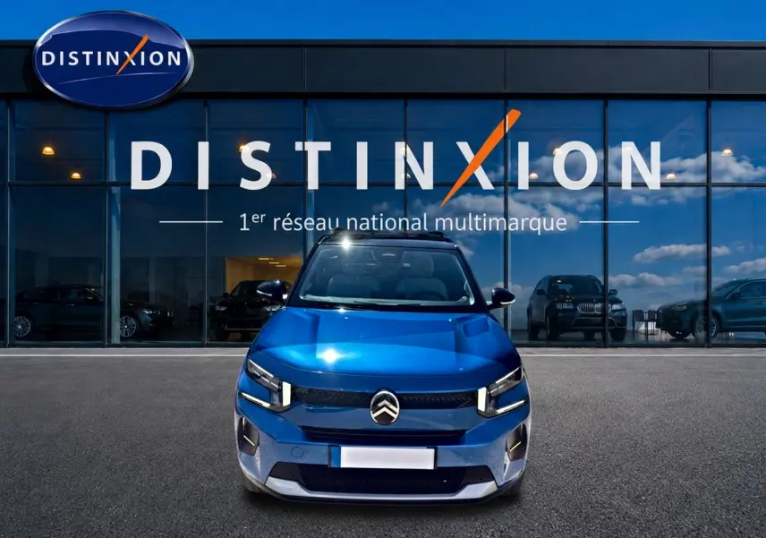 Vue avant d'une Citroën C3 1.2 turbo bleu 2025, avec phares LED et calandre distinctive, devant une vitrine Distinxion.