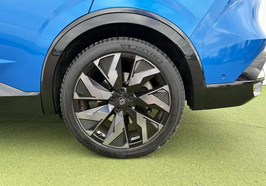 Gros plan sur la roue arrière droite du Renault Rafale Summit Blue avec jante alliage noire et grise au design géométrique.