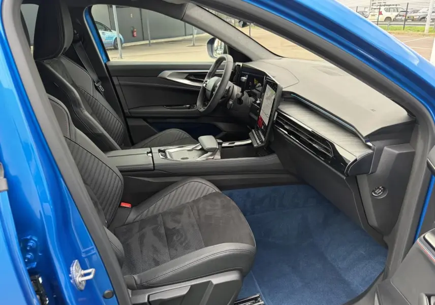 Vue intérieure côté conducteur du Renault Rafale Summit Blue 2025, avec sièges sport noirs et tableau de bord moderne.