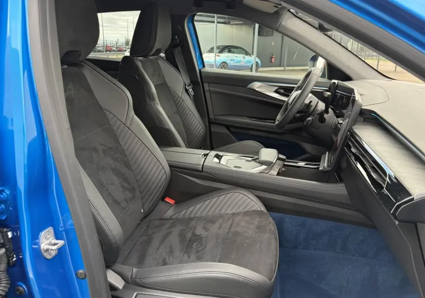 Vue intérieure côté conducteur de la Renault Rafale Summit Blue 2025, sièges sport en Alcantara noir avec surpiqûres rouges.