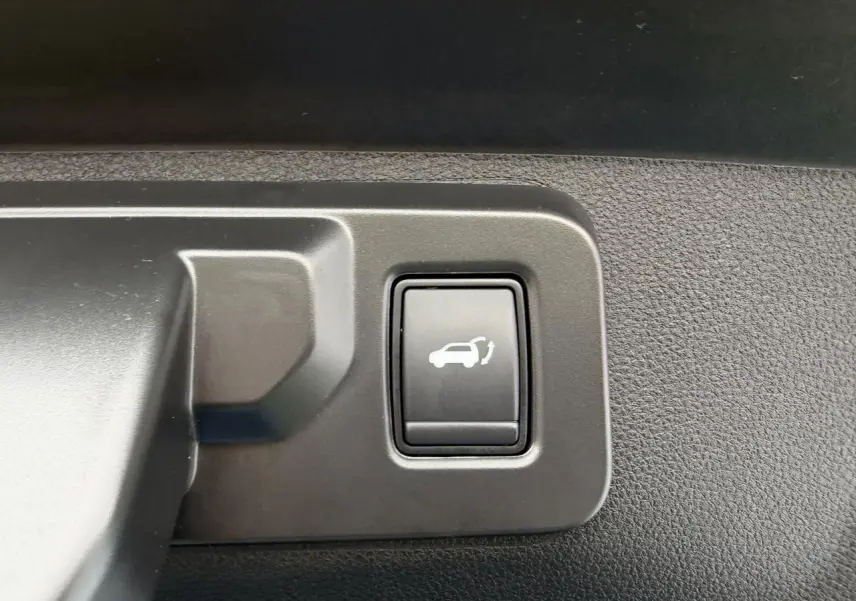 Bouton intérieur noir avec symbole d'ouverture de hayon sur Renault Rafale 2025, détail de commande.