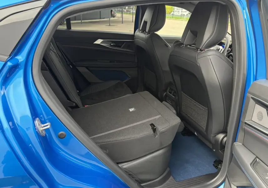 Vue intérieure côté gauche de la banquette arrière rabattue d’un Renault Rafale Summit Blue 2025.