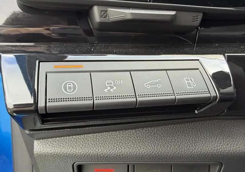 Gros plan sur les boutons de commande gris dans l'habitacle du Renault Rafale 2025 Summit Blue, avec finition noire brillante.