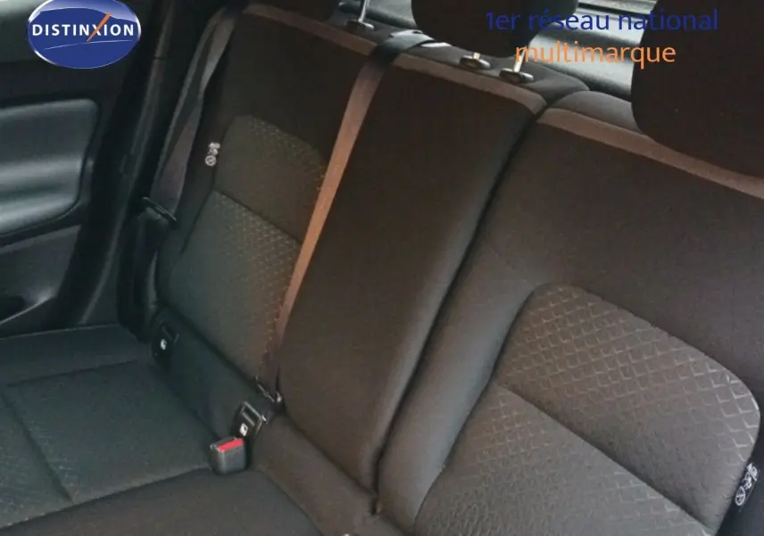 Vue rapprochée des sièges arrière noirs du Nissan Juke gris platine, mettant en valeur les ceintures de sécurité.