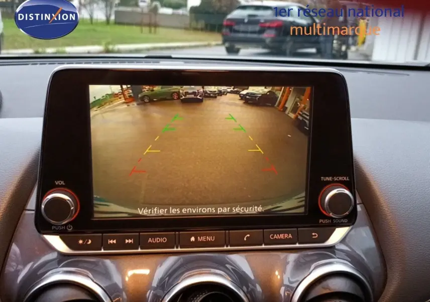 Écran central du Nissan Juke gris platine 2020 montrant la caméra de recul avec guidage coloré en intérieur.