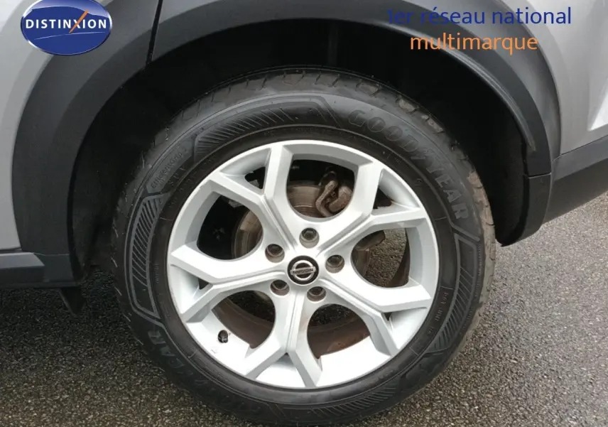 Gros plan sur la roue avant droite d’un Nissan Juke gris platine métal, mettant en valeur la jante alliage 17 pouces.