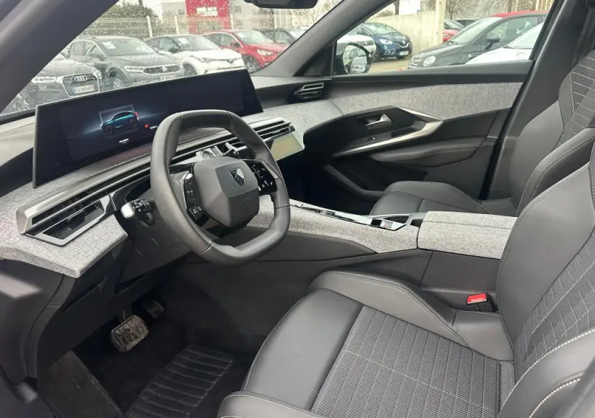 Vue intérieure côté conducteur du Peugeot 3008 Hybrid gris 2025, avec cockpit numérique et sellerie noire.