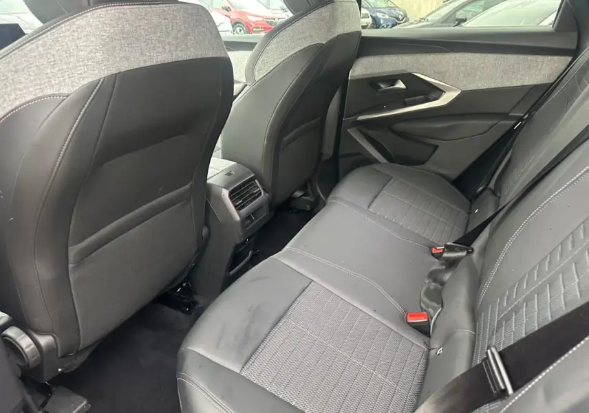 Vue intérieure arrière côté droit du Peugeot 3008 Hybrid gris, montrant les sièges arrière en tissu et cuir avec ceinture de sécurité.