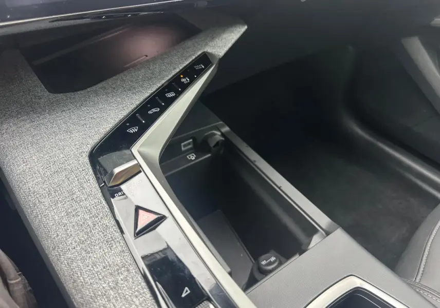 Détail de la console centrale du Peugeot 3008 Hybrid 136 e-DCS6 Allure 2025, avec commandes tactiles et finition tissu gris.