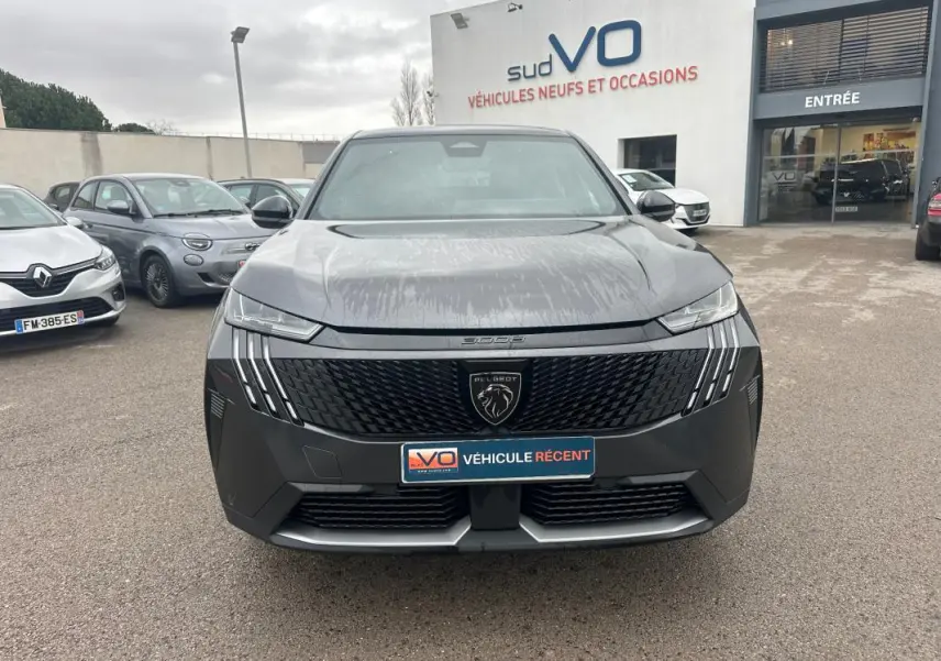 Vue avant d’un Peugeot 3008 Hybrid gris 2025 avec calandre noire et feux LED verticaux distinctifs.