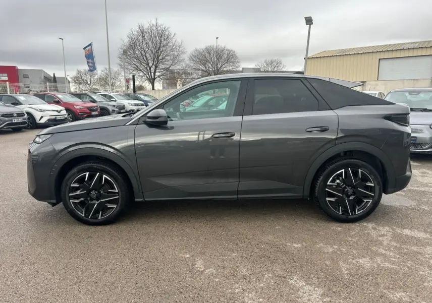 Vue de profil côté gauche d’un Peugeot 3008 Hybrid gris 2025 avec jantes alliage noires de 19 pouces.