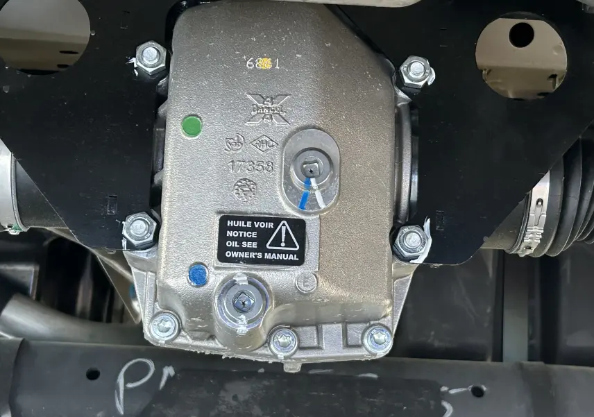 Gros plan sur le boîtier mécanique du pack 4x4 Dangel du Peugeot Partner gris Artense, montrant vis et étiquettes.