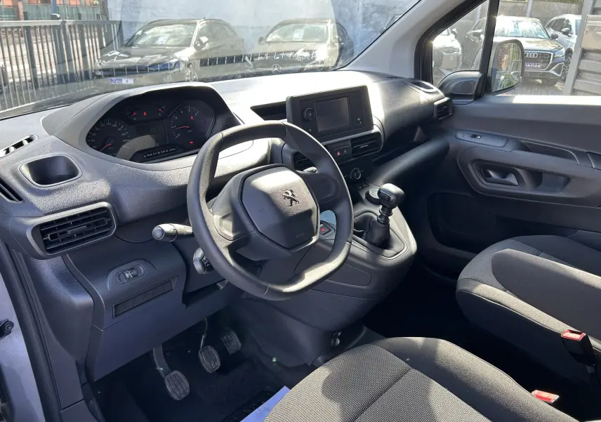 Vue intérieure côté conducteur du Peugeot Partner Dangel 4x4 2025 avec tableau de bord noir et volant compact.