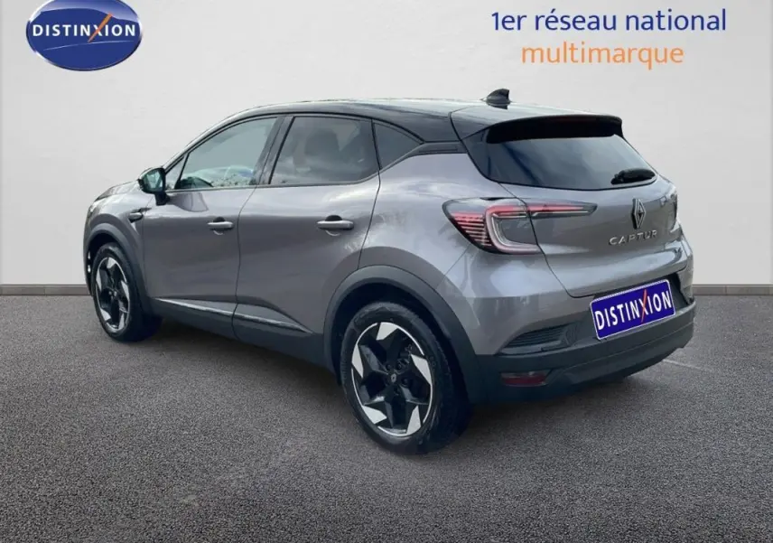 Vue 3/4 arrière droite d'un Renault Captur gris 2025 avec jantes aluminium 18 pouces et toit noir contrasté.