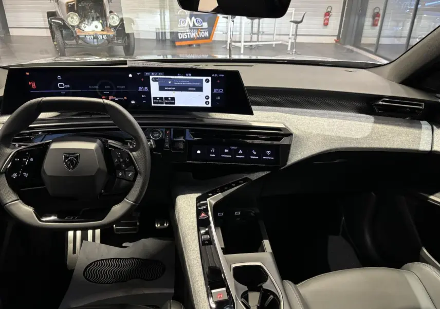 Vue intérieure avant du Peugeot 3008 gris Artense, mettant en valeur le tableau de bord numérique et la console centrale moderne.