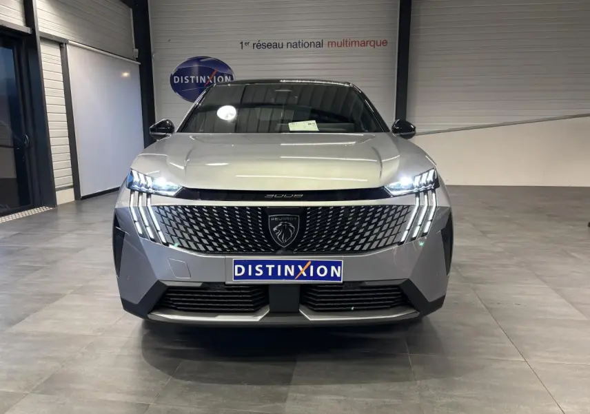 Vue de face du Peugeot 3008 gris Artense avec calandre noire laquée et feux LED à griffes allumés en intérieur showroom.