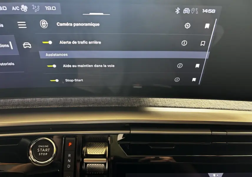 Vue rapprochée de la console centrale du Peugeot 3008 gris clair 2025, avec écran tactile et bouton démarrage visible.