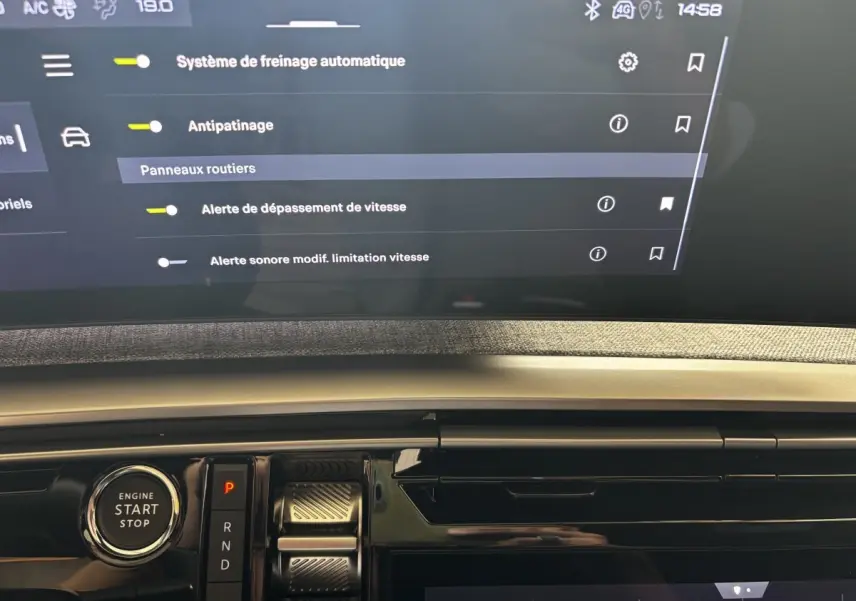 Détail intérieur du tableau de bord Peugeot 3008 gris clair avec bouton démarrage et écran tactile affichant les aides à la conduite.