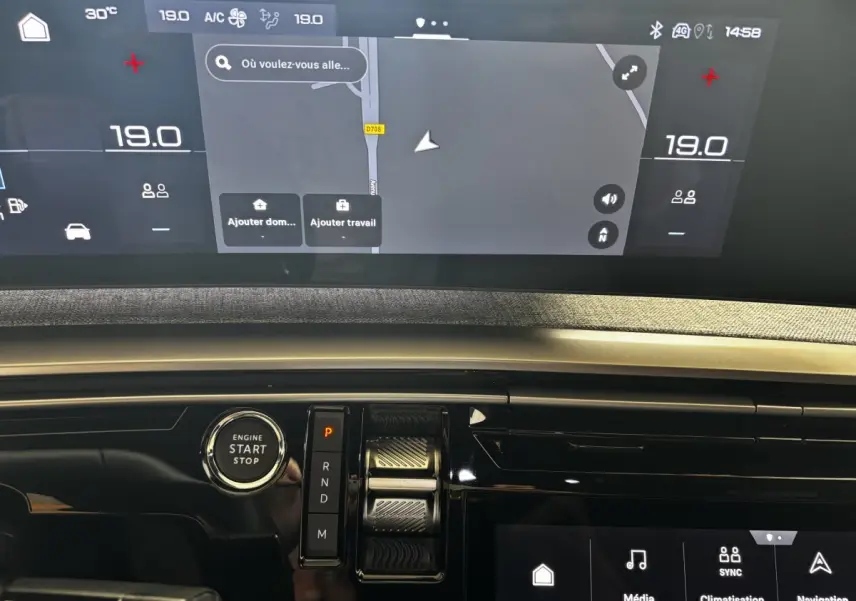 Tableau de bord du Peugeot 3008 gris clair 2025, vue rapprochée sur écran tactile et bouton démarrage.