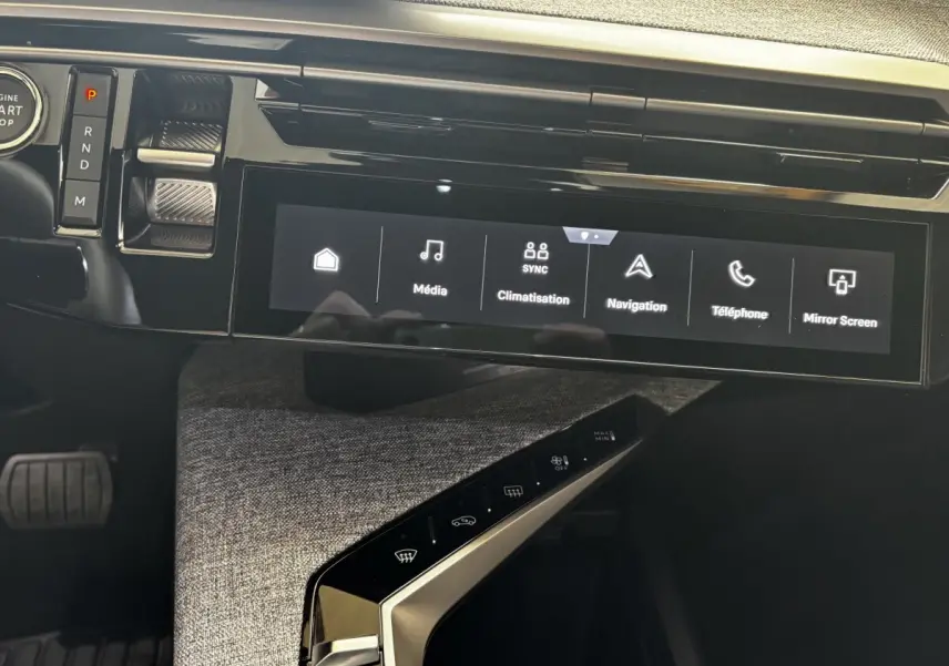 Vue intérieure du tableau de bord du Peugeot 3008 hybride 2025, écran tactile central et commandes modernes.