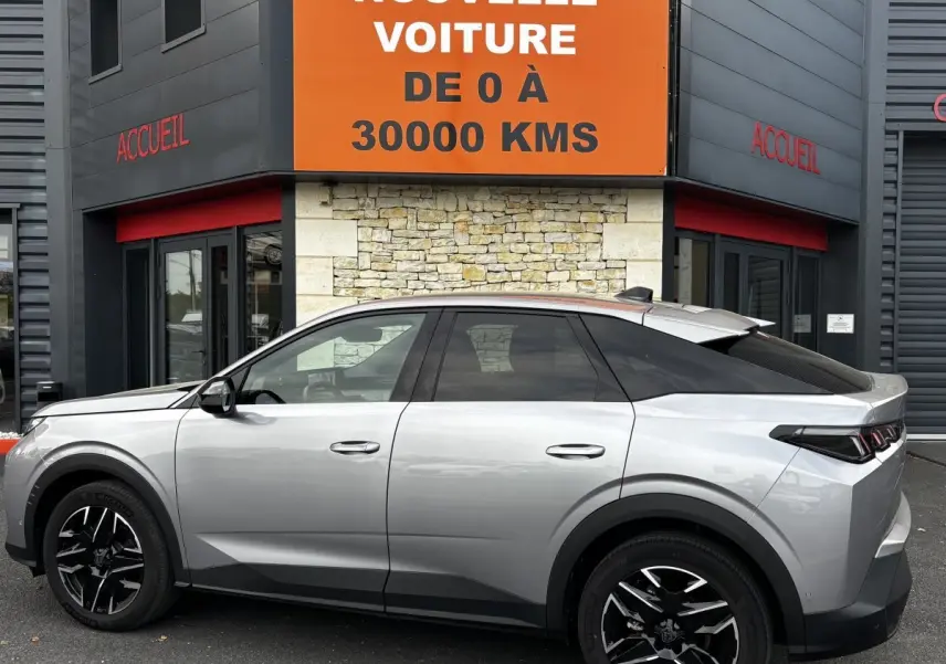 Vue de profil côté gauche d’un Peugeot 3008 gris clair 2025 avec jantes noires et toit noir contrasté.