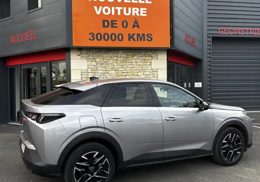 Peugeot 3008 gris clair vue de profil droit, avec jantes noires et toit noir contrastant, stationnée devant un bâtiment.