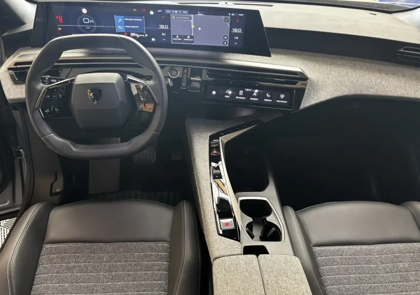 Vue intérieure avant du Peugeot 3008 1.2 Hybrid 145 Allure 2025, tableau de bord numérique et volant cuir multifonctions.