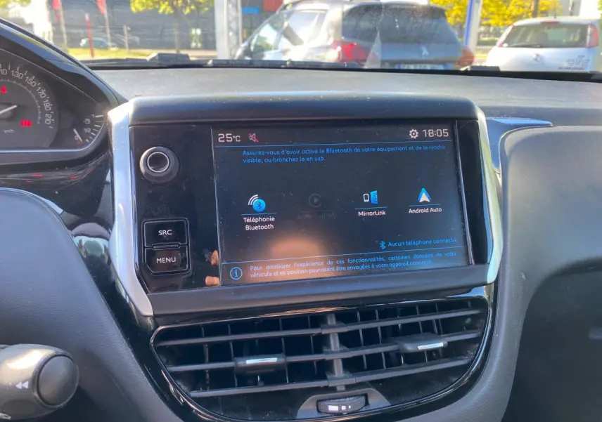 Vue rapprochée de l’écran tactile central du tableau de bord de la Peugeot 208 blanc, affichant les options Bluetooth et MirrorLink.