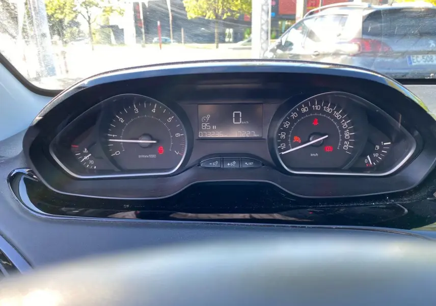 Vue rapprochée du combiné d'instruments numérique de la Peugeot 208 blanche, affichant la vitesse à 0 km/h.