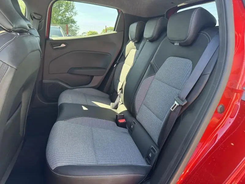 Vue intérieure côté droit des sièges arrière gris et noir de la Renault Clio 1.0 Eco-G 2025 avec portière rouge ouverte.