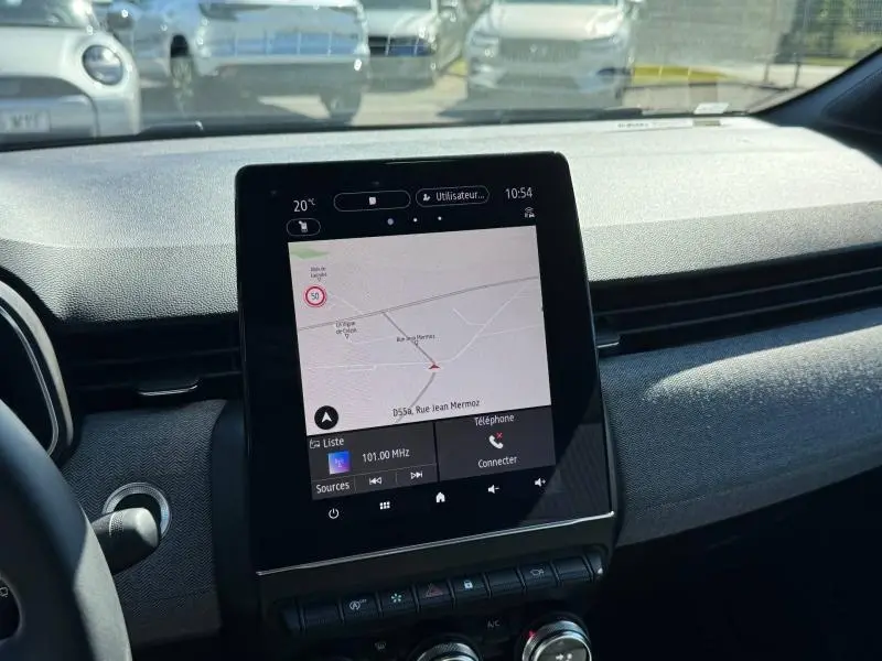 Vue intérieure du tableau de bord de la Renault Clio 2025, écran tactile central affichant la navigation, ambiance grise.