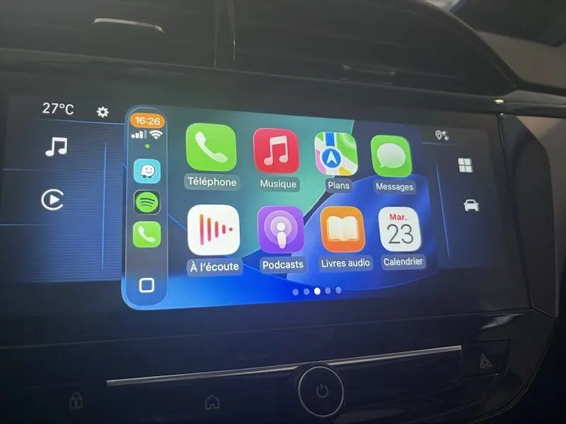 Écran tactile central de l’Opel Corsa 2025 affichant l’interface Apple CarPlay avec plusieurs applications colorées.