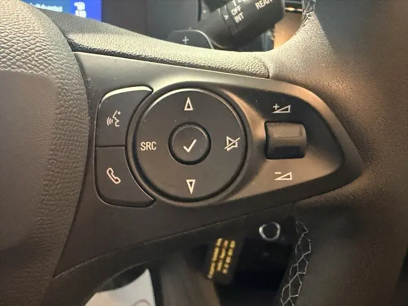 Gros plan sur les commandes au volant côté gauche d’une Opel Corsa gris 1.2 Turbo 100 Edition BVA8 2025.