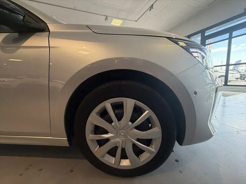 Gros plan sur la roue avant droite d’une Opel Corsa gris clair 2025, mettant en valeur la jante et l’aile avant.