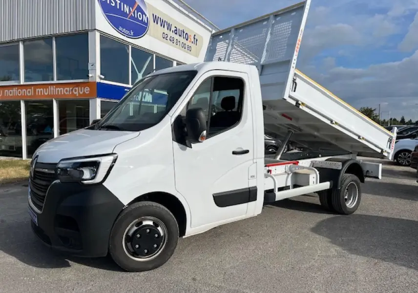 Renault Master blanc 2024 vue 3/4 avant droit avec benne basculante relevée sur parking extérieur.