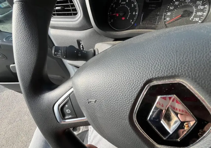 Vue rapprochée du volant Renault Master 2024 avec logo central, commandes intégrées et tableau de bord partiellement visible.