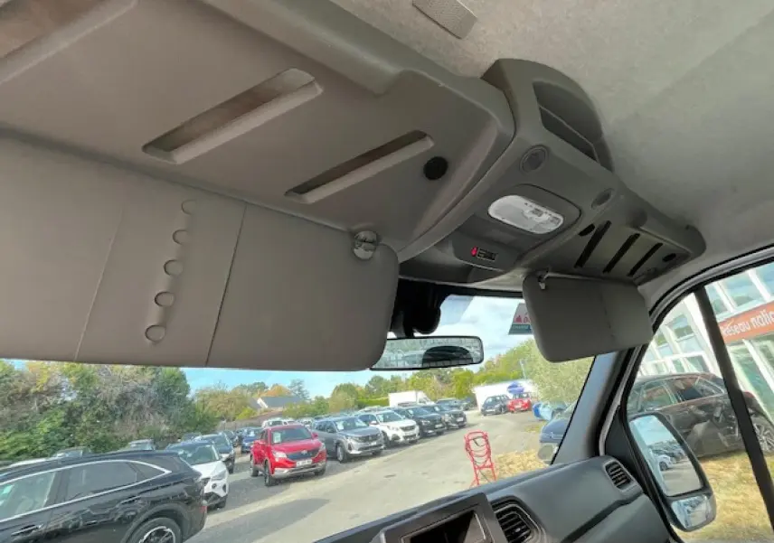 Vue intérieure du poste de conduite du Renault Master blanc 2024, montrant le pare-soleil et le tableau de bord côté droit.